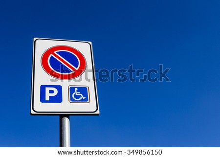 Road sign no parking, except for wearers handicap.