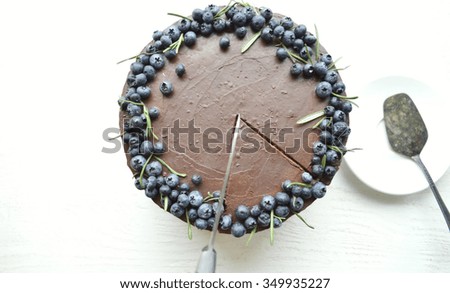 chocolate cake with blueberries and rosemary on a table