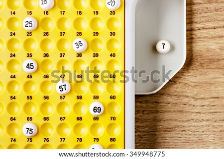 Electronic bingo balls on yellow board. Horizontal image viewed from above. Royalty-Free Stock Photo #349948775