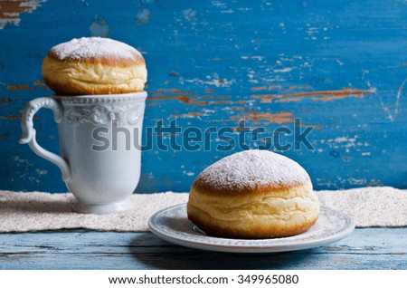 Donut in powdered sugar on a wooden background in rustic style. Selective focus.