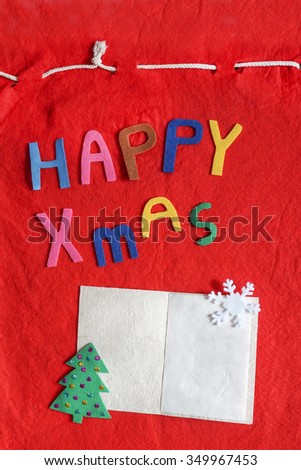Christmas colorful background with postcard and christmas wishes over red felt background