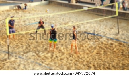 Blurry focus of beach scenery in england beach with a group of people playing beach volleybal represent the blurry background and people activity concept related idea.