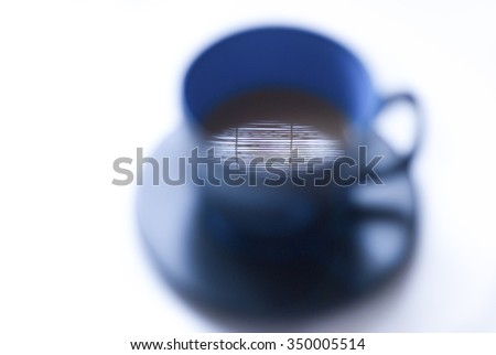 Morning coffee/Image of a large cup of coffee defocused with the image reflected on the coffee surface in focus, isolated on white.