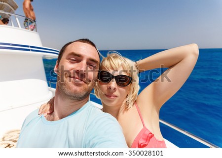 Cruise ship couple taking selfie self portrait photo romantic. Happy lovers, woman and man traveling on vacation travel sailing on open sea ocean enjoying romance. 