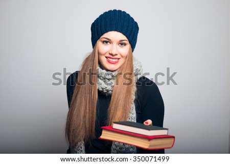 bright beautiful girl holding a book, a photo studio, isolated on a gray background
