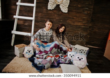 Young fashion winter  couple at wooden background 