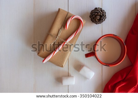 Christmas handmade gift box with candy cane and xmas ornaments on white wooden table

