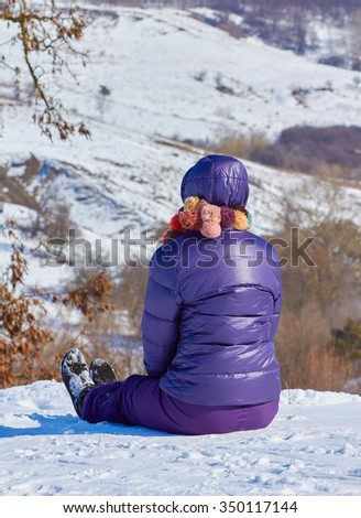 Young girl in a ski suit on a snowy winter background