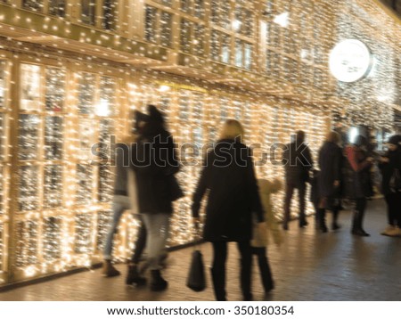 Abstract blurred background: Christmas decorations and Christmas tree in the windows of the town's shops and cafes with blur bokeh. Great Christmas background.