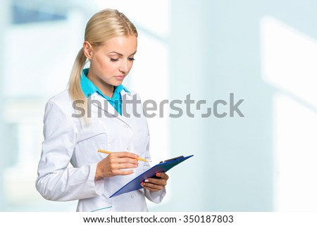 Portrait of happy female doctor holding blank paper on clipboard