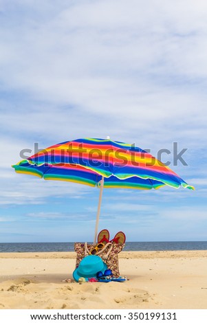 Sunshade with a bag of sunbathers on the beach.