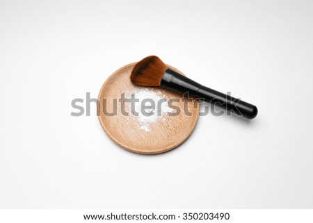 makeup powder and brush on a plate 