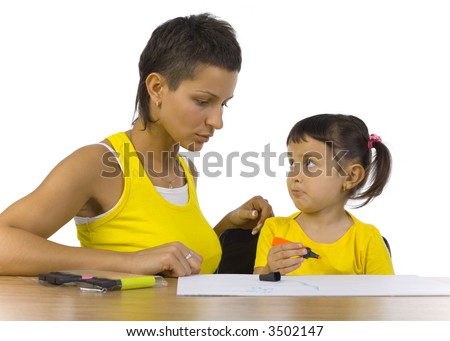 Young mother sitting with sad daughter at desk. Girl looking at mother. White background