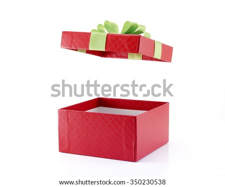 closeup open and empty gift box wrapped in red paper with grid pattern with lime green ribbon and folded bow (lid is floating in the air) isolated on white background, surprise in holiday festive Royalty-Free Stock Photo #350230538