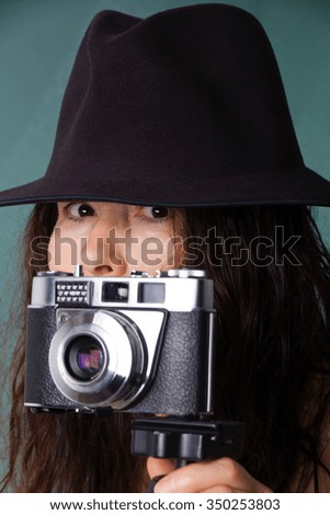 Woman with hat takes photos with old camera