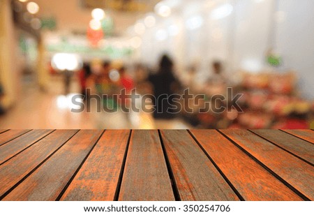 Wooden table and  blurred photo of department store shopping mall center and people background