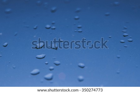 Water drops on window, blue sky background