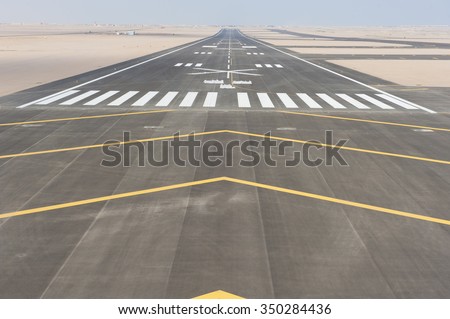Aerial panoramic view of a commercial airport runway with connections and taxiways Royalty-Free Stock Photo #350284436