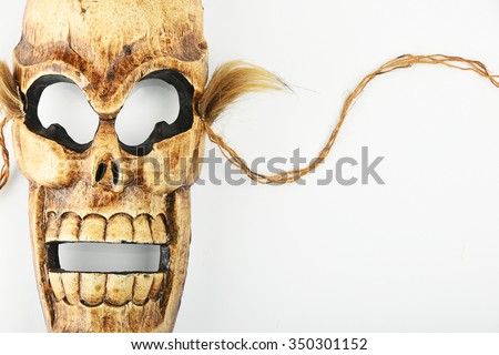 Handmade wooden carved creepy skull death joker mask on white background