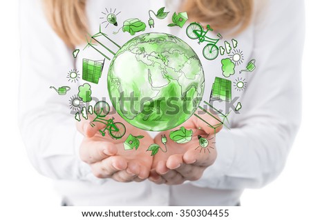woman as if holding a sphere with a green picture of eco energy icons arranged in circle, earth in the centre, concept of clean and safe environment, breast view