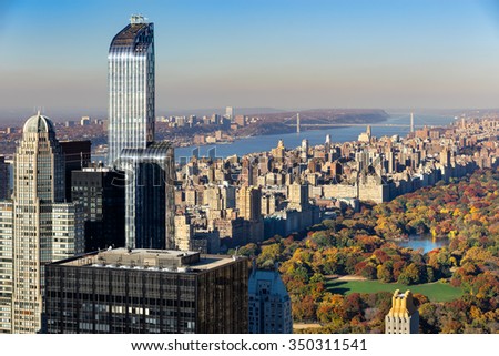 Aerial view of Central Park in autumn with Upper West Side in Manhattan, New York City. The view includes Midtown skyscrapers, the Hudson River and the George Washington Bridge.