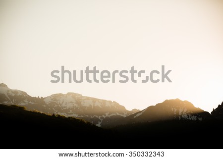 Sunrise - This is a beautiful image of the warm sun streaming through the mountain peaks in Telluride, Colorado. Shot with a warm color tone. 