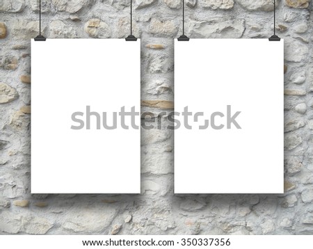 Double hanged paper sheet frames with clips on medieval stone wall background