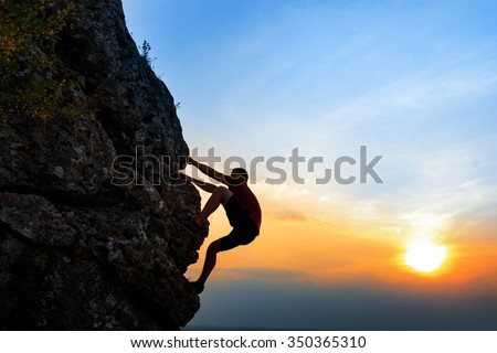 A Silhouette of a Rock climber at sunset background. Sport and active life Royalty-Free Stock Photo #350365310