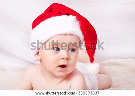 Beautiful little baby celebrates Christmas. New Year's holidays. Baby in Santa hat