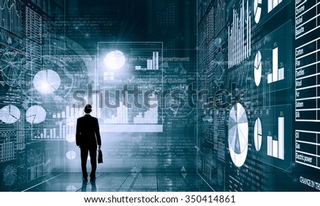 Rear view of businessman with suitcase and infographs on virtual panel