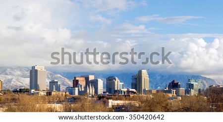 Panorama of downtown Salt Lake City in the winter with low clouds and mountains in the background, Utah, USA