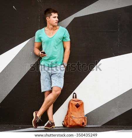 Slylish fashion man traveling with a bag Royalty-Free Stock Photo #350435249