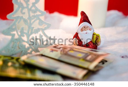 Santa Claus with candles and money on red background