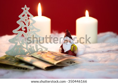 Santa Claus with burning candles and money on red background