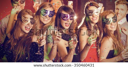Flying colours against friends in masquerade masks drinking champagne Royalty-Free Stock Photo #350460431