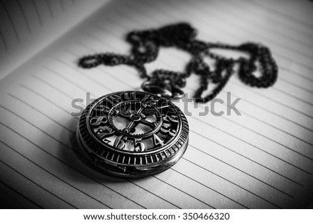 Vintage pocket watch on note book time concept,Black and white
