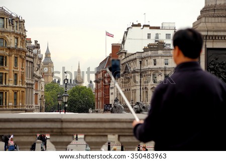 Blurred man takes selfie photo on the Trafalgar Square, London with the Big Ben in the background.