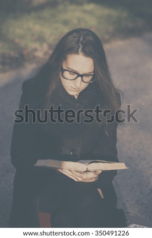 Vintage photo of woman with book on retro suitcase