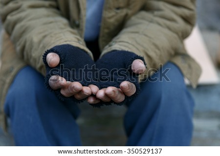 Man in need. Unhappy homeless man is holding hands to get help. Royalty-Free Stock Photo #350529137