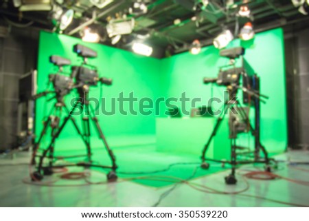 Blurred image against television green studio with camera.