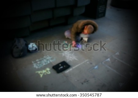 The homeless man painting the street floor with chalk color paint represent the people concept related idea.