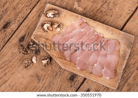 dried pork tenderloin on a rough wooden rustic table - selective focus, copy space