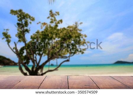 Defocus and blur image of terrace wood and Beautiful sea image of blurred sunbed at beach  for background usage. 
