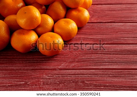 Ripe mandarins on a red wooden table