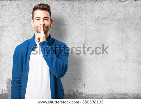 young man doing a silence gesture