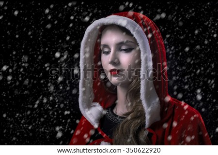 sad woman in red hood under snow
