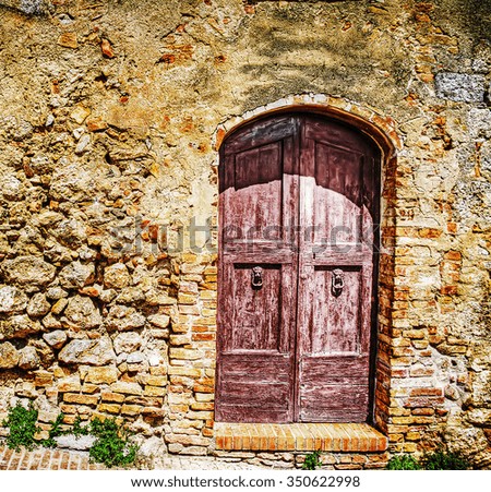 wooden door in a brick wall in hdr in San Gimignano
