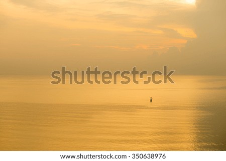 sunset  of flashing buoy on sea 