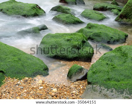 Dutch kryptonite, green rocks in the surf of the ocean at twilight Royalty-Free Stock Photo #35064151