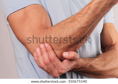 Man With Pain In Elbow. Pain relief concept Royalty-Free Stock Photo #350675540